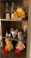 Contents of three shelves - dolls, candles,