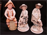 Three bisque figurines of children in period