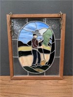 Framed stained glass panel of a farmer