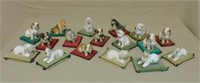 Porcelain Dog Figures on Velvet Pillows.