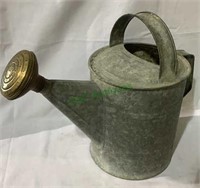 Antique galvanized metal watering can with a