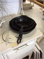 Set of three cast iron frying pans