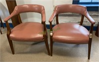 Matching pair of pink leather-like office chairs.