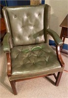 Padded green leather-like wooden chair with button