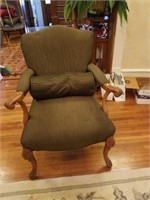 Green upholstered chair with round pillow