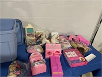 Barbies and Barbie furniture in plastic tote