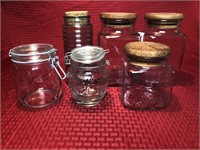 6 assorted and unmatched glass kitchen jars.
