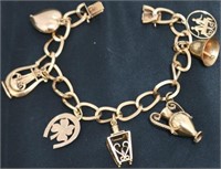 18KT YELLOW GOLD CHARM BRACELET WITH 7 CHARMS. 4