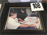 FRAMED PICTURE OF PETE ROSE SIGNING JERSEY