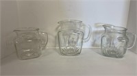 (3) matching creamer pitchers of different sizes