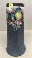 Vase w/ handpainted bluebirds sitting on a floral