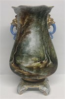 Scenic footed vase depicting a young boy fishing o