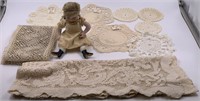 Lot with antique porcelain doll and stack of laces