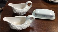 Two gravy boats and a butter dish