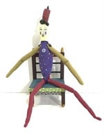 Odd folk art figure in wood chair