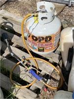 Propane tank half full with a weed burner.