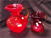 Two pitchers: one tangerine with amber handle,