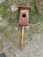 Birdhouse on a stake.  about a foot tall