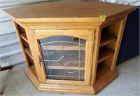Rolling oak TV stand with glass door and shelves