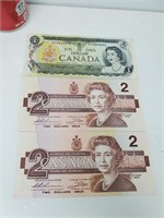 2 billets de 2 dollars canadiens et 1 billet de 1