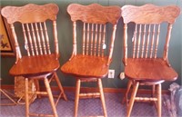 Three Oak swivel bar chairs