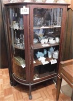 Antique oak china cabinet with curved glass on the