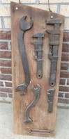 Collection of RR wrenches on barn board