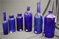 Six old blue glass bottles