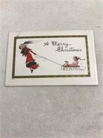A merry Christmas woman pulling sled postcard