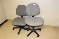 Two grey rolling office chairs