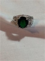 Size 7 1/2 with emerald green colored stone