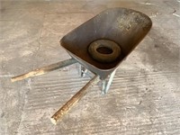 Old wheel barrow, one handle is a fence post