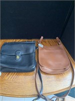 Two Coach purses.  One black and one brown.
