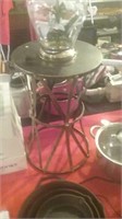 Metal plant stand with lamp encasing flowers