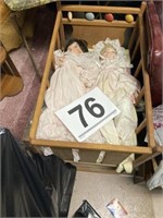 2 porcelain dolls in crib