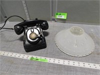 Antique party line telephone and a glass lamp shad