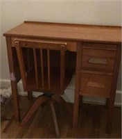Vintage wooden child’s desk and swivel chair.