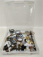 container full of various pins, jewelry, etc.