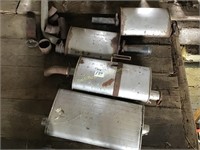 Pile of used mufflers and exhaust parts