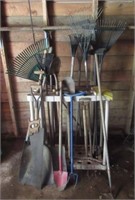 Assortment of yard tools including rakes,