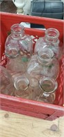 7 glass milk jugs different sizes and crate