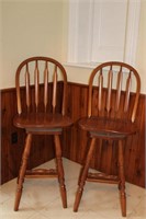 Two oak arrow back swivel bar stools with foot