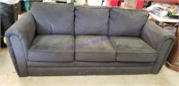 Charcoal colored couch  64 inches long, sits firm