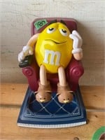 LG YELLOW PEANUT M&M IN LOUNGE CHAIR ON RUG REMOTR