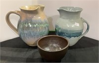 Three handmade pottery pieces, two pitchers