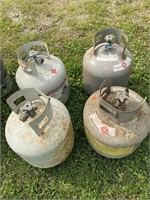 4 Propane gas tanks. Two appear to be full