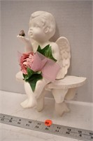 Small hanging wooden shelf with ceramic cherub