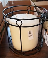 Large unlit candle in metal holder
