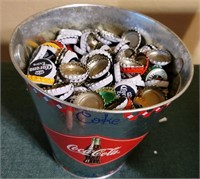 metal coke bucket full of beer bottle caps