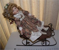 Wicker & metal doll sleigh + porcelain doll